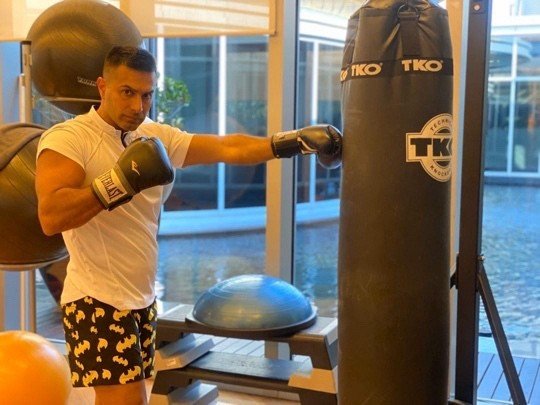 Mah in gloves working the heavy bag